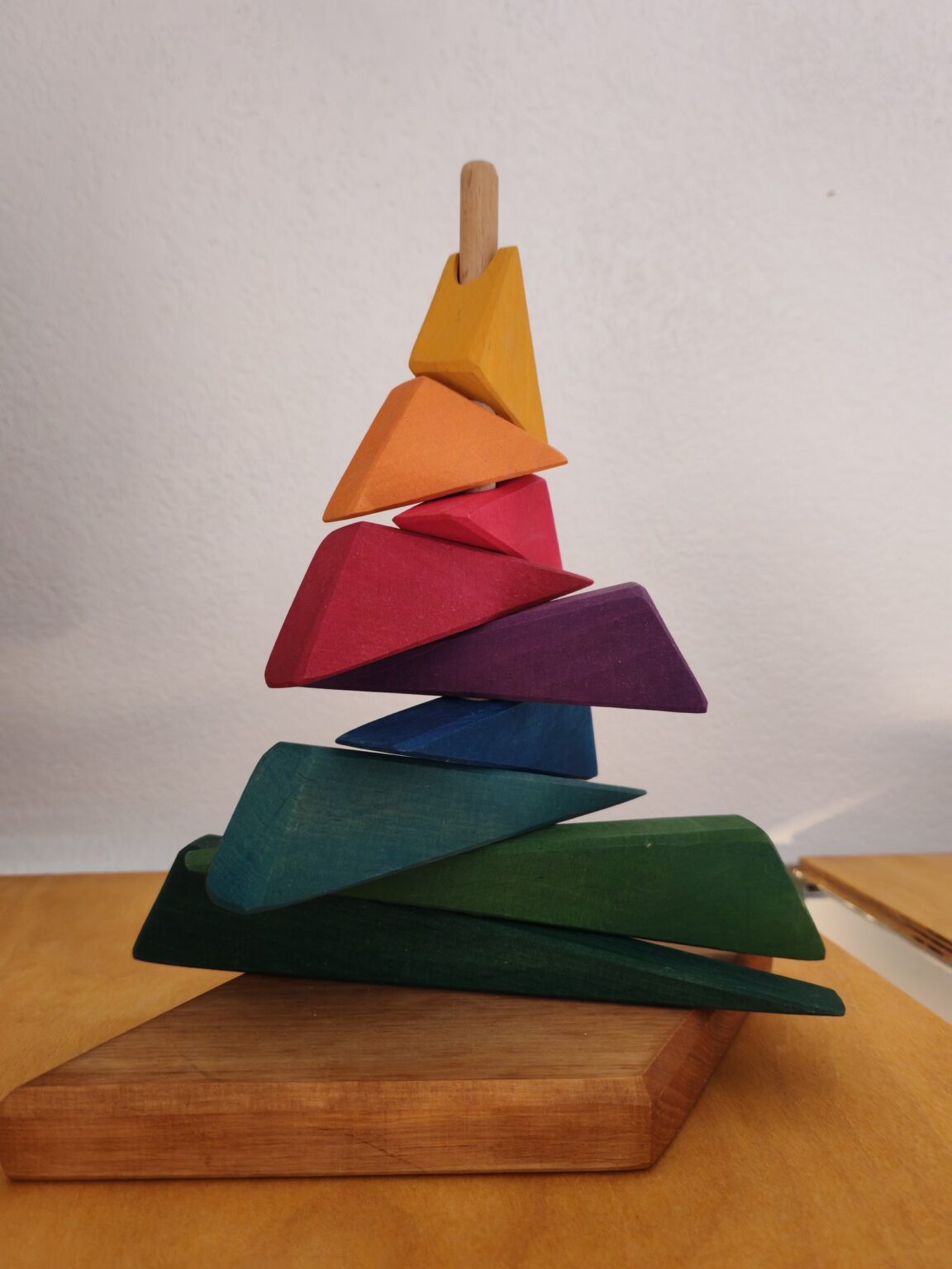Gestapelter Holz-Regenbogen auf einem Holzsockel