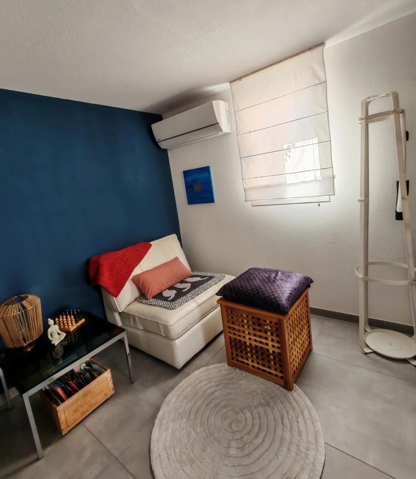 Leseecke mit tiefblauer Wand und weißem Sessel in der Villa·51