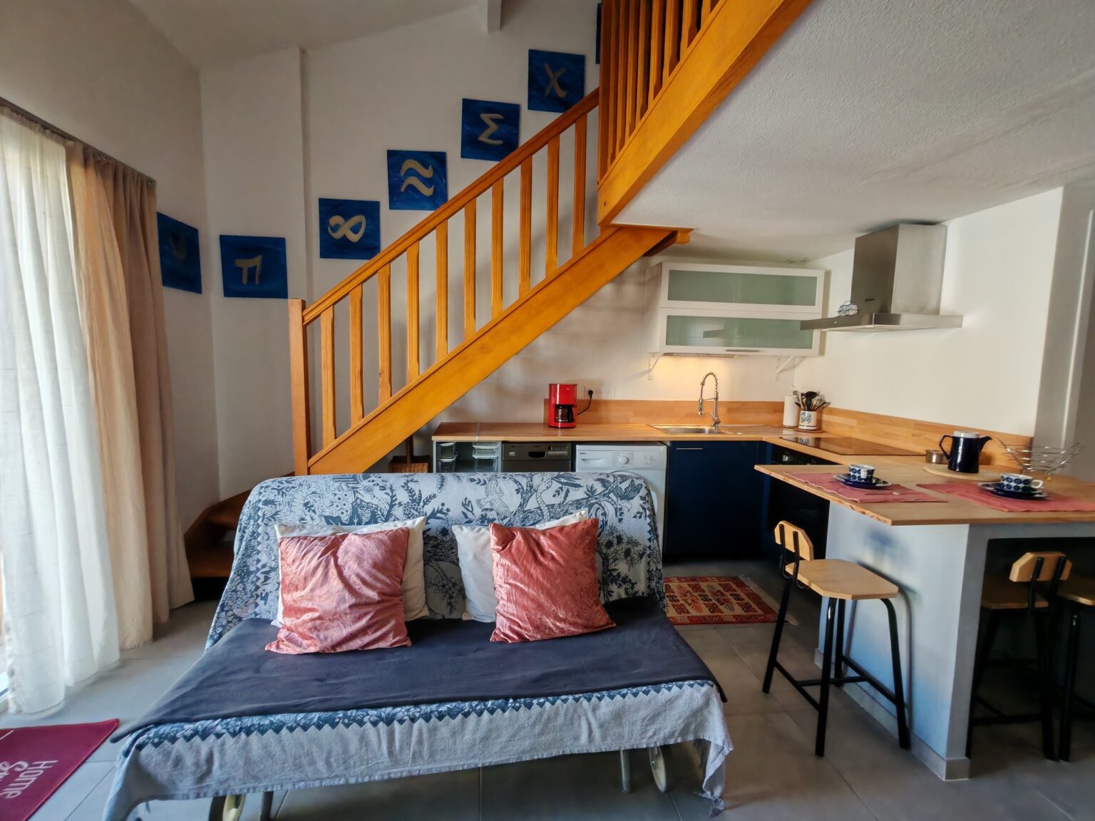 Offener Wohnbereich mit Sofa, Holztreppe und Küche