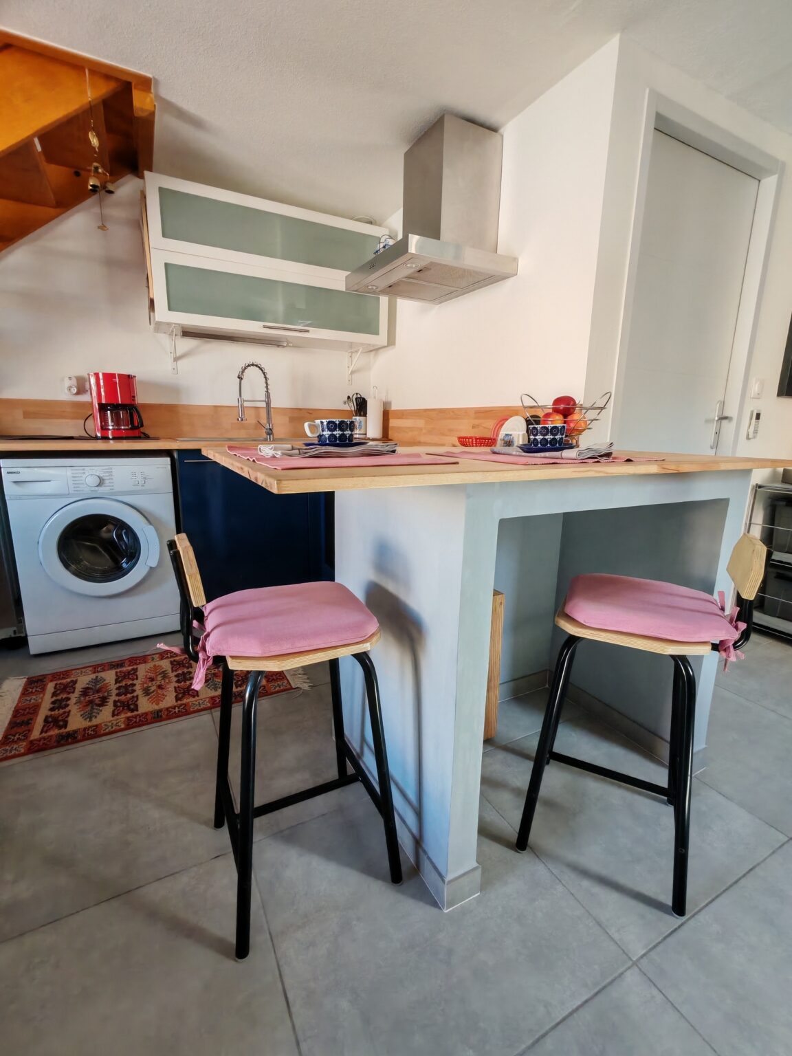 Küche mit Barhockern, Theke und Waschmaschine